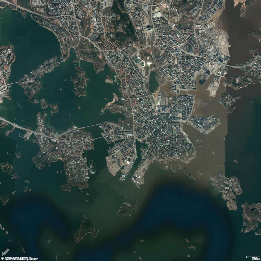 Aerial view of a coastal city with dense urban areas, waterways, and islands.