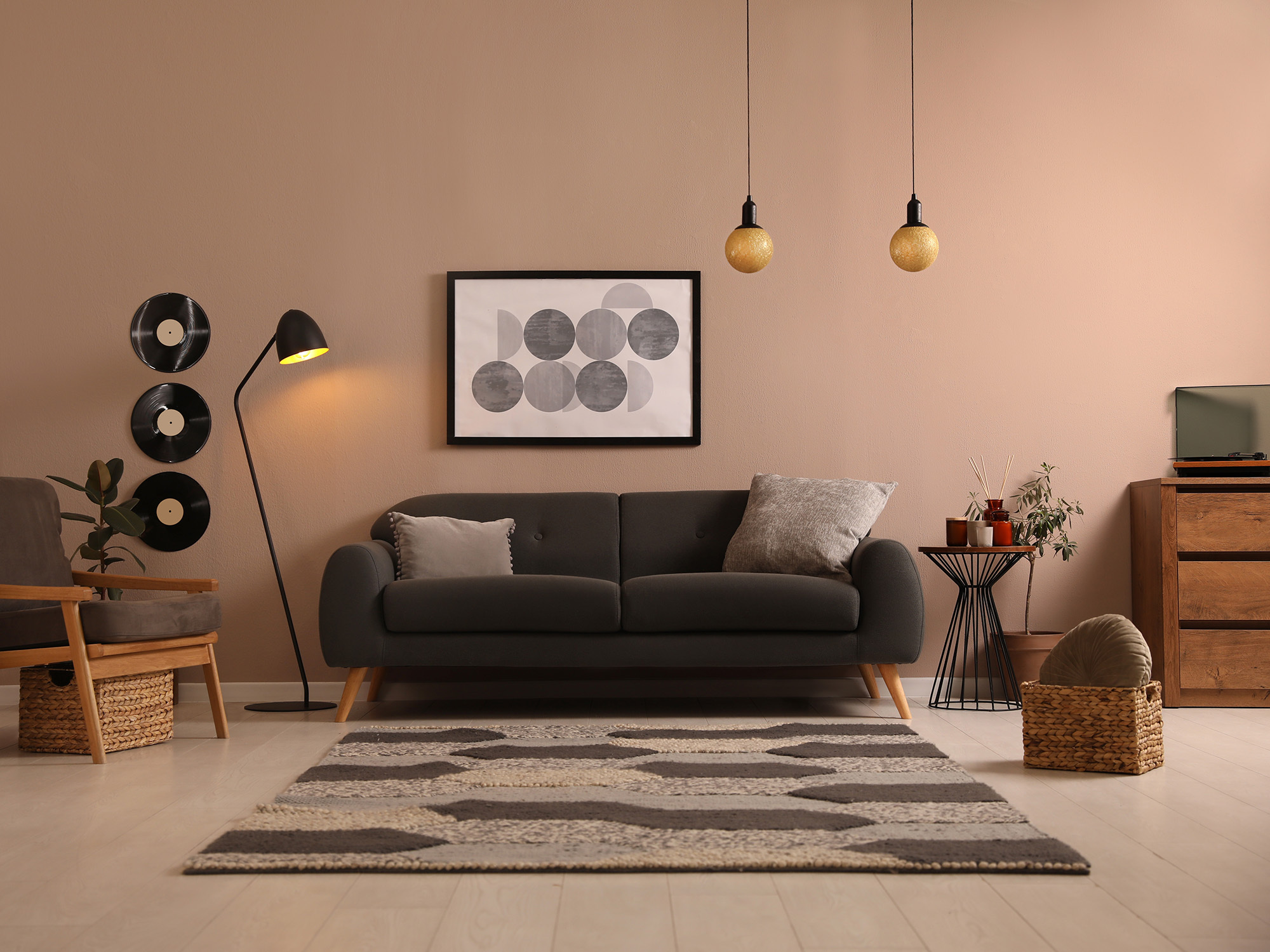 Un canapé gris moderne du milieu du siècle dans une pièce entourée d’autres décorations.